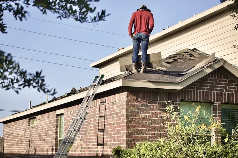 Professional roofer working on a residential roof in Rife